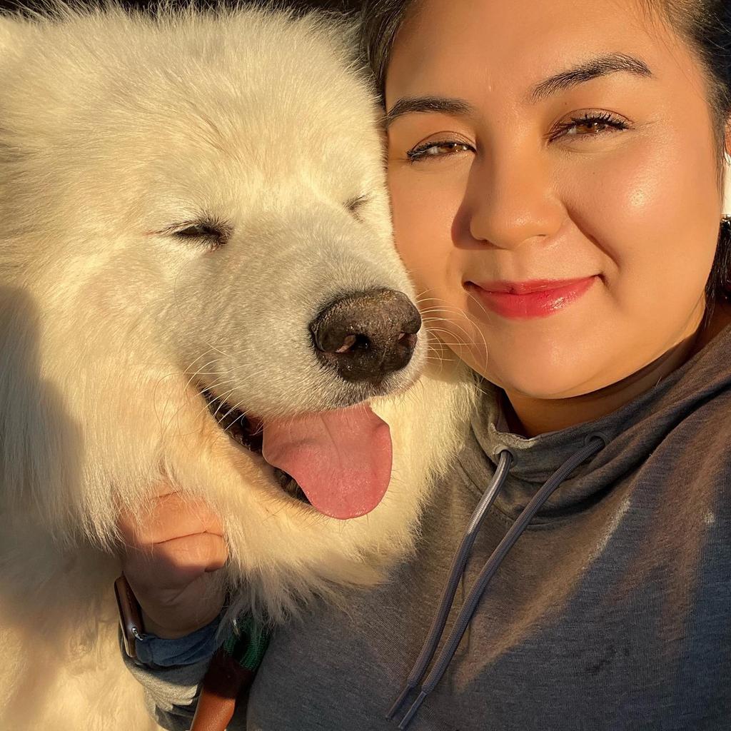 Terry smiling with her fluffy white Samoyed